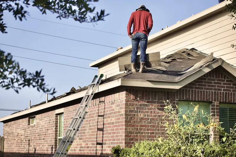 Professional roofer working on a residential roof in Coralville
